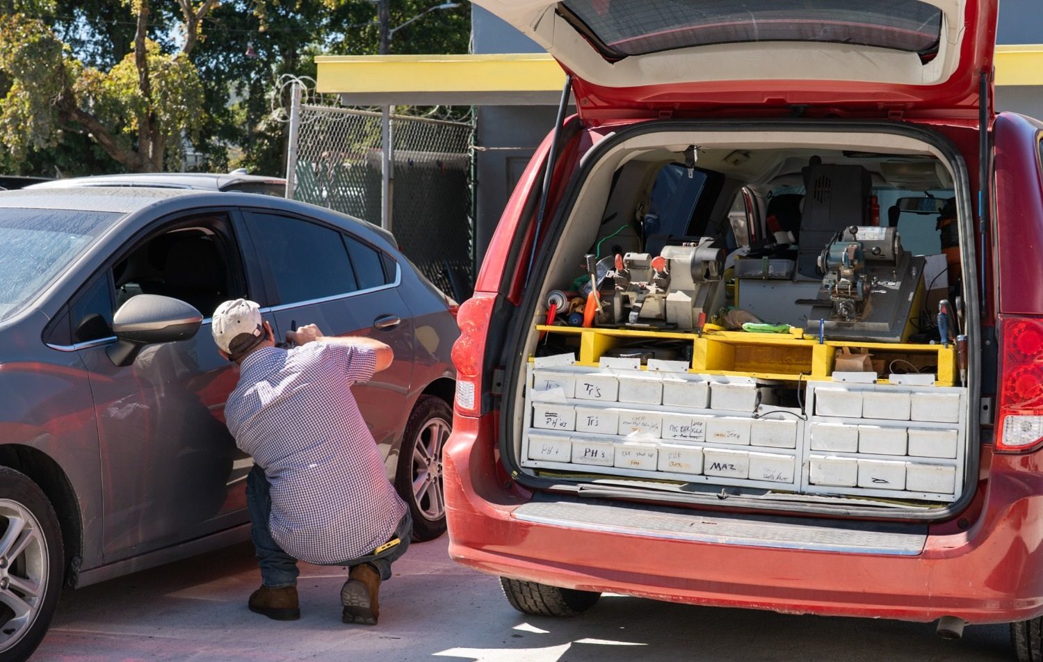 Laptop running key-cutting software beside a key machine — car key programming in Broward County